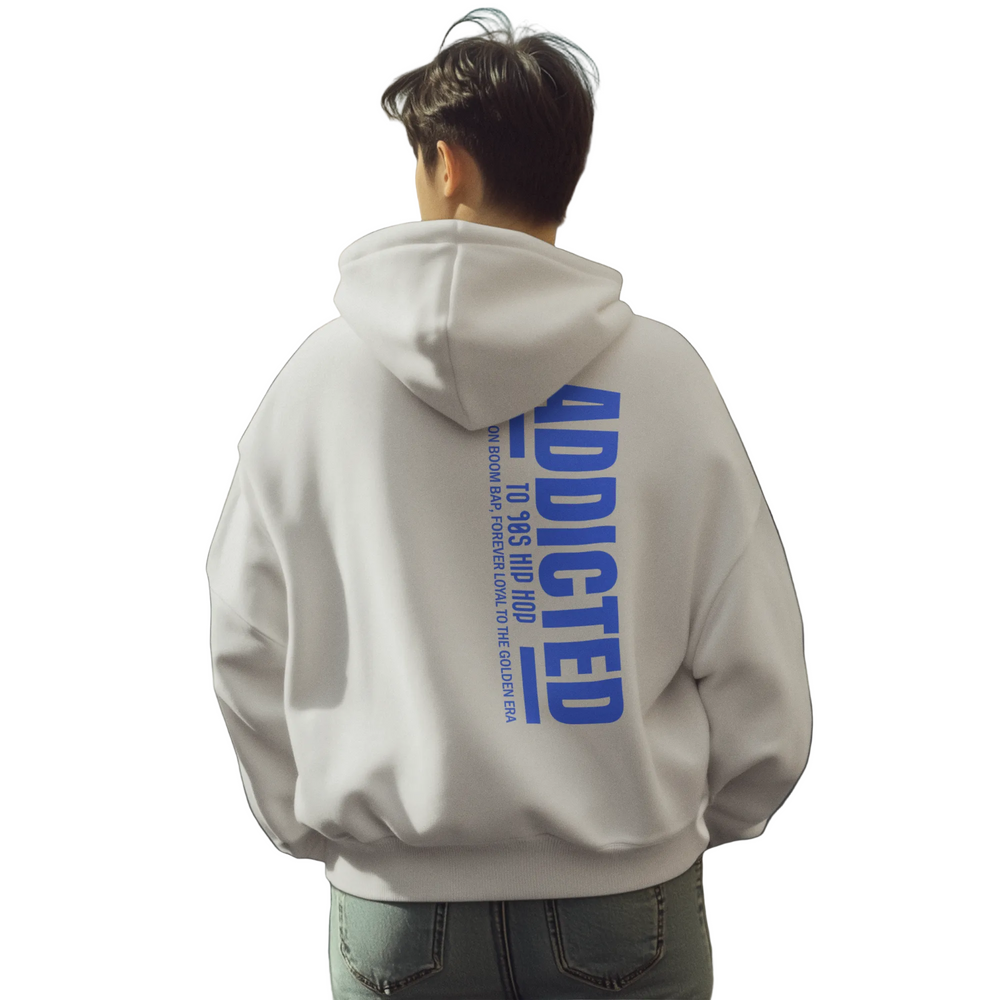 Person wearing a hoodie with 'ADDICTED' text on the back in an urban setting