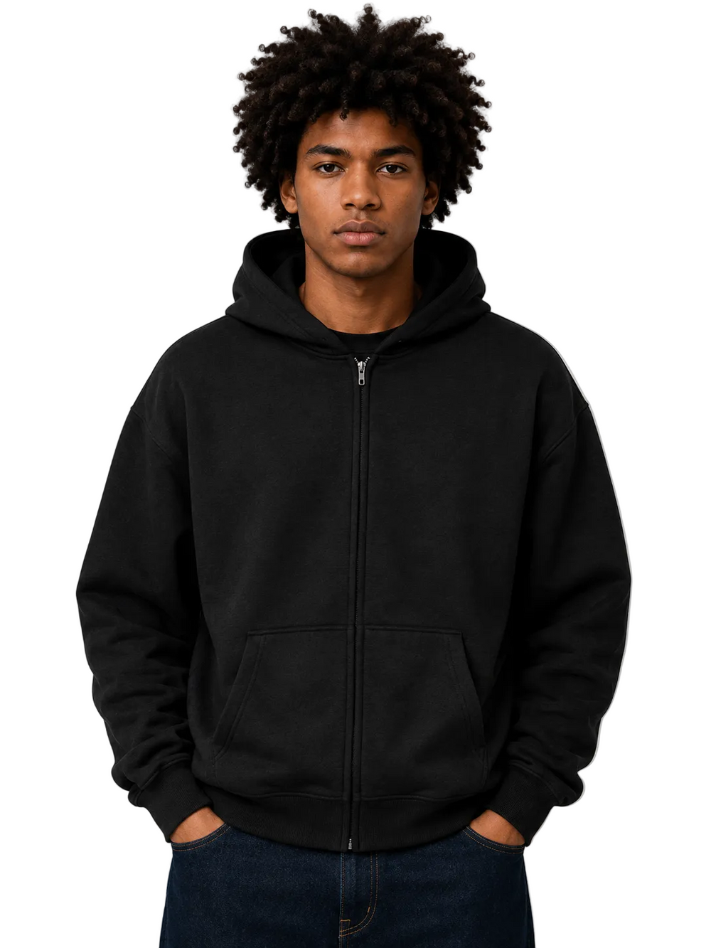 A man with an afro hairstyle wearing a black full-zip hoodie and dark blue jeans, standing against a neutral gray studio background.