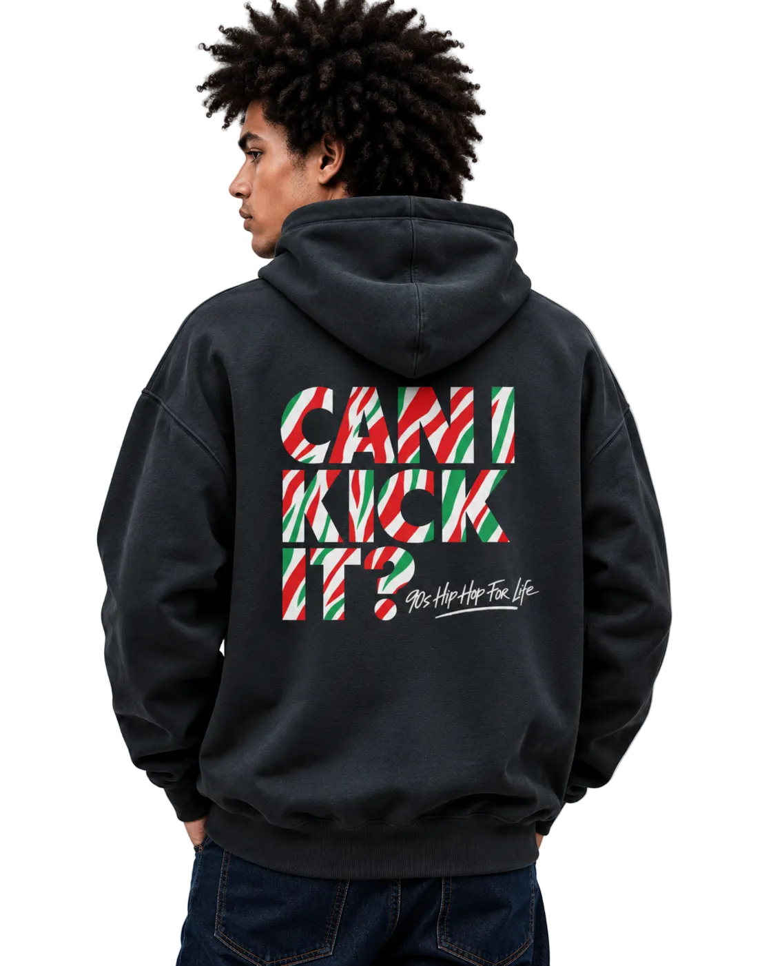 A man wearing a black hoodie from the back, featuring a large graphic on the back with the text 'CAN I KICK IT?' in red, green, and white striped candy cane shapes, and 'As Hip As Your Life' in white script below it.