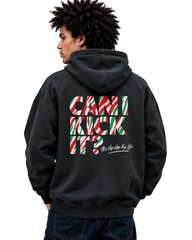 A man wearing a black hoodie from the back, featuring a large graphic on the back with the text 'CAN I KICK IT?' in red, green, and white striped candy cane shapes, and 'As Hip As Your Life' in white script below it.