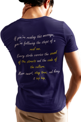 Person wearing a blue t-shirt with a message on the back, standing indoors.