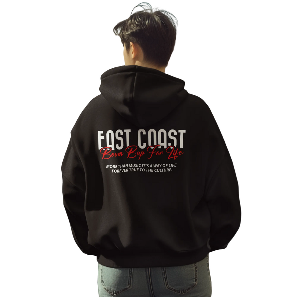 Person wearing a black hoodie with 'East Coast' text on the back in an urban setting