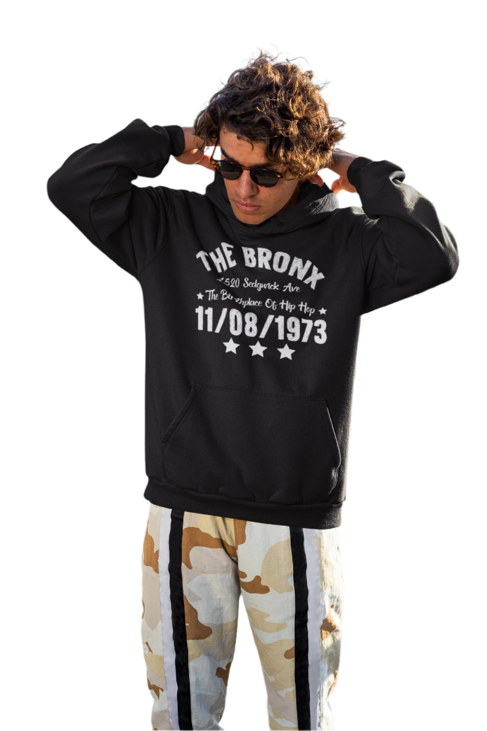 A person wearing a black hoodie with 'THE BRONX' and additional text on it, raising their fist in the air.